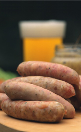 raw sausages with beer in background