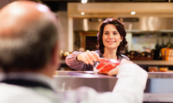 woman purchasing meat from butcher